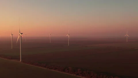 Wind driven generators rotate in rural field at sunset Video stock 167056534