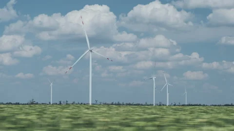 Wind driven generators with turning blades in green field Video stock 161223641