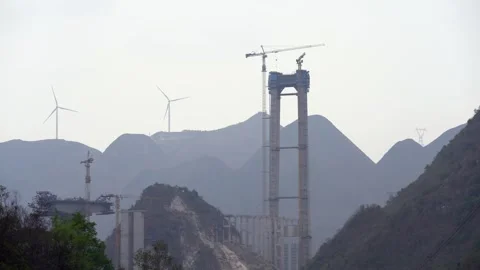 Wind driven generators working near a highway bridge in China Stock Footage 270219106