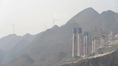 Wind driven generators working near a highway bridge construction site in China Stock Footage 270220184