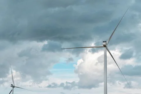 Wind energy generators on the field under stormy dramatic sky. Horizontal b.. Stock Photos