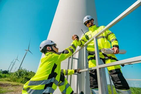 Wind energy technicians perform maintenance on wind turbine in a sunny envi.. Stock Photos