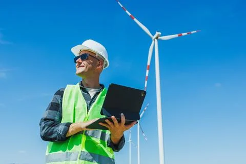 Wind energy worker checks data at wind farm during bright and sunny day wit.. 스톡 사진