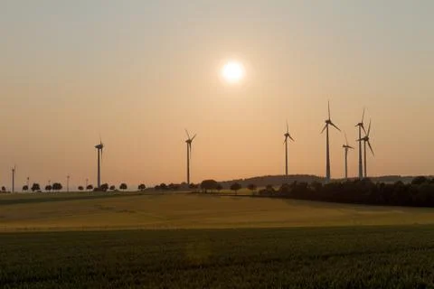 Wind engines in rural scene with setting sun Stock Photos
