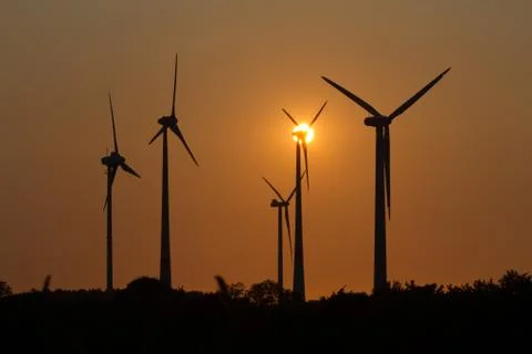 Wind engines in rural scene with setting sun Stock Photos
