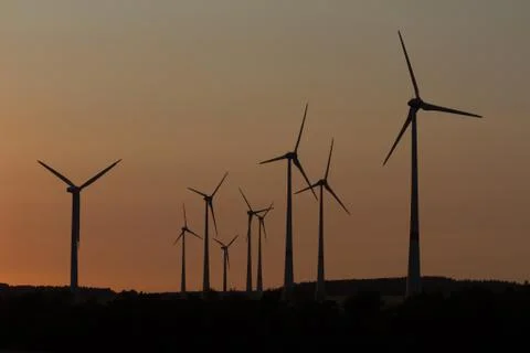 Wind engines in rural scene with setting sun Stock Photos