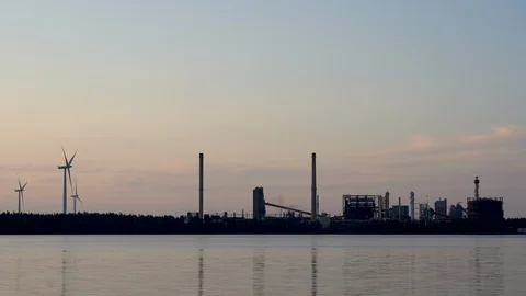 Wind farm with active oil refinery in same shot Video stock 117348823