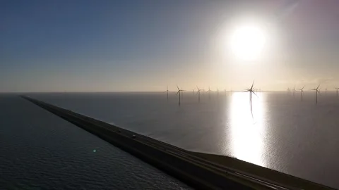 Wind farm and curving Afsluitdijk seen from over the sea Stock Footage 331828524