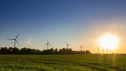 Wind farm on a field during sunset with clear sky time lapse. Stock Footage 75961526