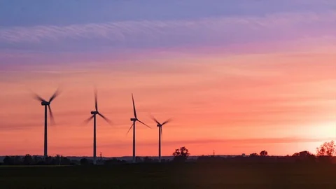 Wind farm on a field during sunset with colorful sky time lapse. Stock Footage 75961662