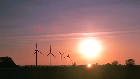 Wind farm on a field during sunset with colorful sky. Sustainable living. Stock Footage 75961781