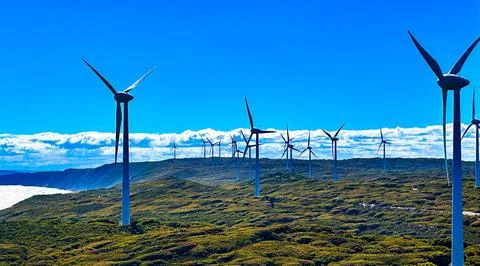 Wind Farm Generating Clean Energy With Spinning Blades Under Blue Sky Stock Photos