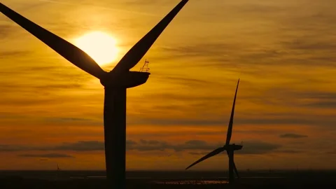 Wind farm generating clean renewable energy at sunset. Wind turbine turning Stock Footage 309292151