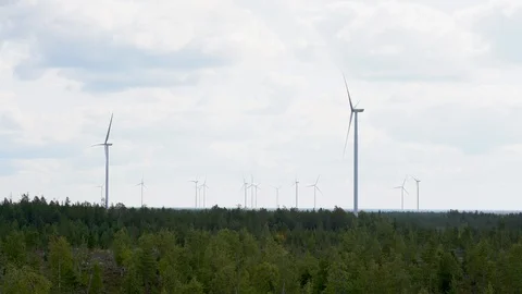 Wind farm, multiple wind turbines over pine forest in Finland 動画素材 117356128
