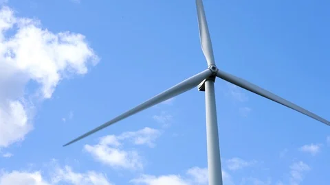 Wind farm, single wind turbine, close up of blades, on blue summer sky. Stock-Footage 117353314