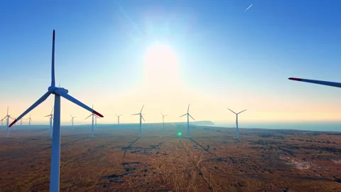 Wind farm turbines at sunset over coastal steppe, Bulgaria Stock Footage 336726145
