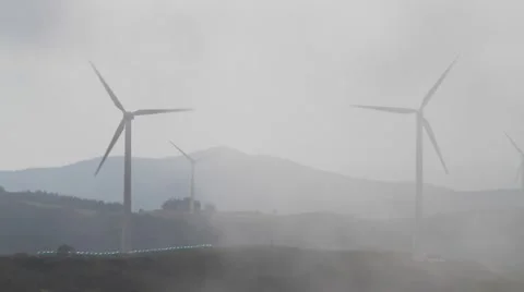 Wind farm with wind turbines making green energy covered with foggy clouds Stock Footage 42666251