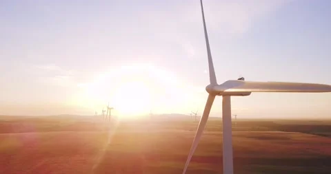 Wind Farm Wind Turbines - orbiting a wind turbine with sunrise in the background Stock Footage 157357978