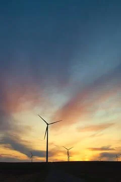 Wind farm windmills in dramatic light and mystical sunset atmosphere Stock Photos