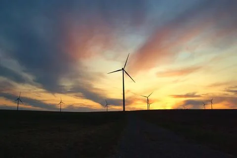 Wind farm windmills in dramatic light and mystical sunset atmosphere Stock Photos