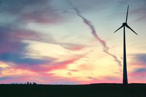 Wind farm windmills in dramatic light and mystical sunset atmosphere Stock Photos