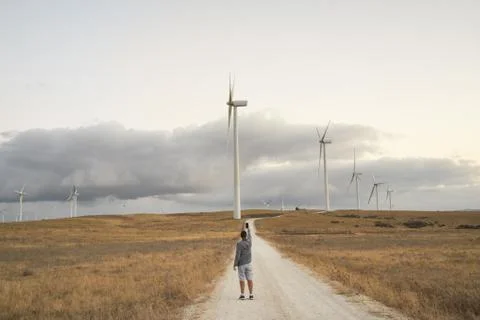 Wind farm with windmills. A person is taking a picture with his mobile phone Stock Photos