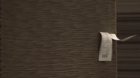 Wind flatters labels on cardboard stack in warehouse Video stock 295152368