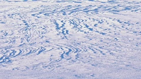 Wind-formed figures on white snow blanket of a lake in Finland Stock Footage 102923375