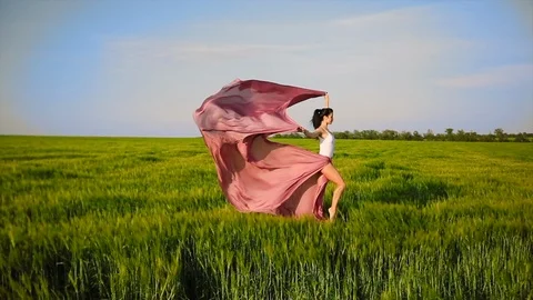 Wind of freedom and change. Professional modern dancer in pink fabric dress Stock Footage 119239256