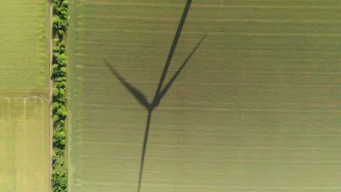 Wind generator and its shadow on a field with wheat part #05 库存影片 132201347