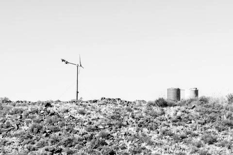 Wind generator and two water tanks on a hill. Monochrome Stock Photos