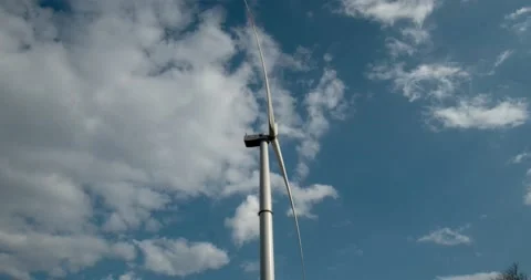 Wind generator on a background of blue sky and floating clouds. Green electricit Stock Footage 130744162