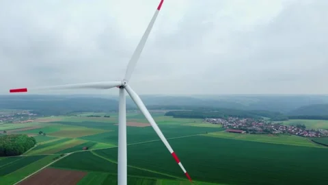 A wind generator on a green meadow in the distance is a town Stock Footage 155598686