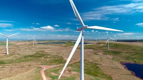 Wind generator in the process of generating electrical energy in a wind farm Stock Photos