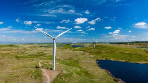 Wind generator in the process of generating electrical energy in a wind farm Stock Photos