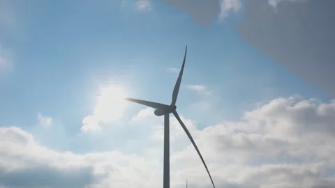 Wind generator in the process of working with the sun behind Stock Footage 260607011