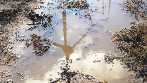 Wind generator reflected on dirty puddle. Stock Footage 97463628