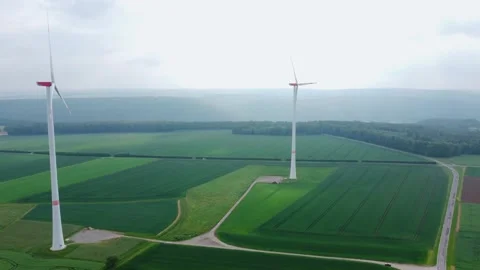 The wind generator stands on the field by the road 動画素材 155594931