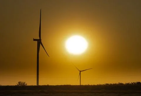 Wind generators on the background of the sky without clouds at sunset near the Stock Photos