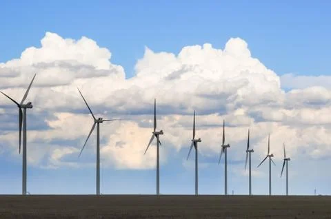 Wind Generators Silhouetted in the Evening under beautiful clouds Stock Photos