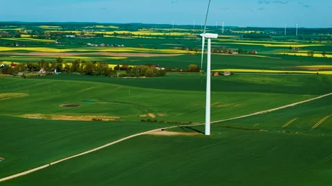 Wind generators spinning across wide farmland producing ecological electricity. Stock Footage 328358827