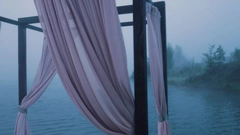 Wind gently blowing curtains over misty lake Video stock 288242653