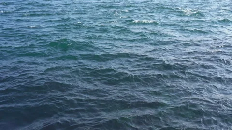 Wind gusting across deep blue ocean waters generates rhythmic waves Stock Footage 291338535