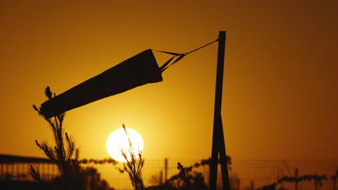 Wind indicator at sunset sways majestically in air. Gentle air currents on warm Stock Footage 246261534