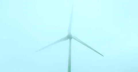 Wind machine producing alternative energy in foggy morning. Turbine rotating in Stock Footage 221849556