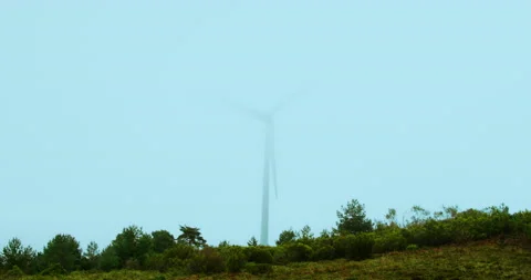 Wind machine producing alternative energy in foggy morning. Turbine rotating in Stock Footage 223007131