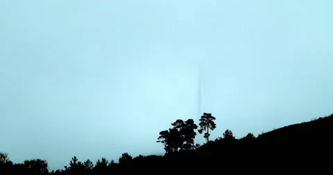 Wind machines producing alternative energy in foggy morning. Turbines rotating Stock Footage 222217226