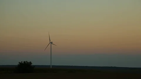 Wind mill on the field spinning. Eco friendly energy source. Sunrise during a Stock Footage 93368526
