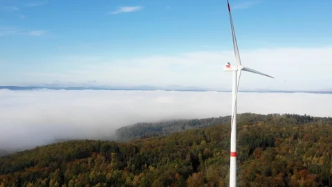 Wind mill power generator standing in autumn forest with clouds in the backgr Stock Footage 119832312