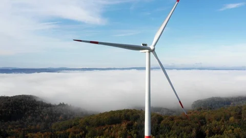 Wind mill power generator standing in autumn forest with clouds in the backgr Stock Footage 119832400